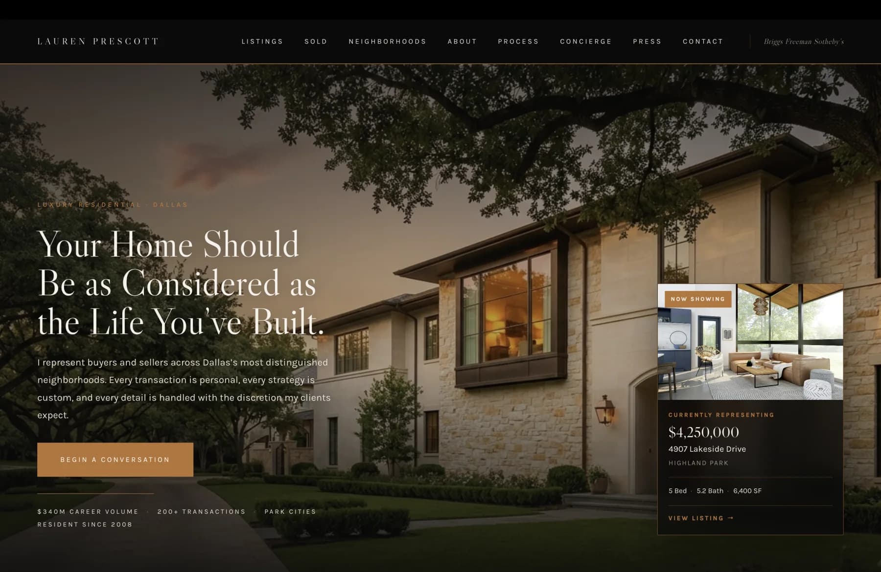 The home page of Lauren Prescott's luxury residential practice in Park Cities, Dallas. A thin black navigation strip carries the wordmark in serif caps and a single row of links reading Listings, Sold, Neighborhoods, About, Process, Concierge, Press, and Contact, with a small Briggs Freeman Sotheby's brokerage credit on the right. The hero photograph beneath is a stone-and-glass traditional residence at golden hour, mature trees framing the lawn and warm light spilling from the windows. Overlaid in serif at left is the headline 'Your Home Should Be as Considered as the Life You've Built,' followed by a short first-person paragraph and a brand-orange button reading 'Begin a Conversation.' A floating dark card on the right anchors the Now Showing listing at 4807 Lakeside Drive, Highland Park, $4,250,000, 5 bed, 5.2 bath, 8,400 square feet. A bottom stat row reads $340M career volume, 200-plus transactions, Park Cities resident since 2008.