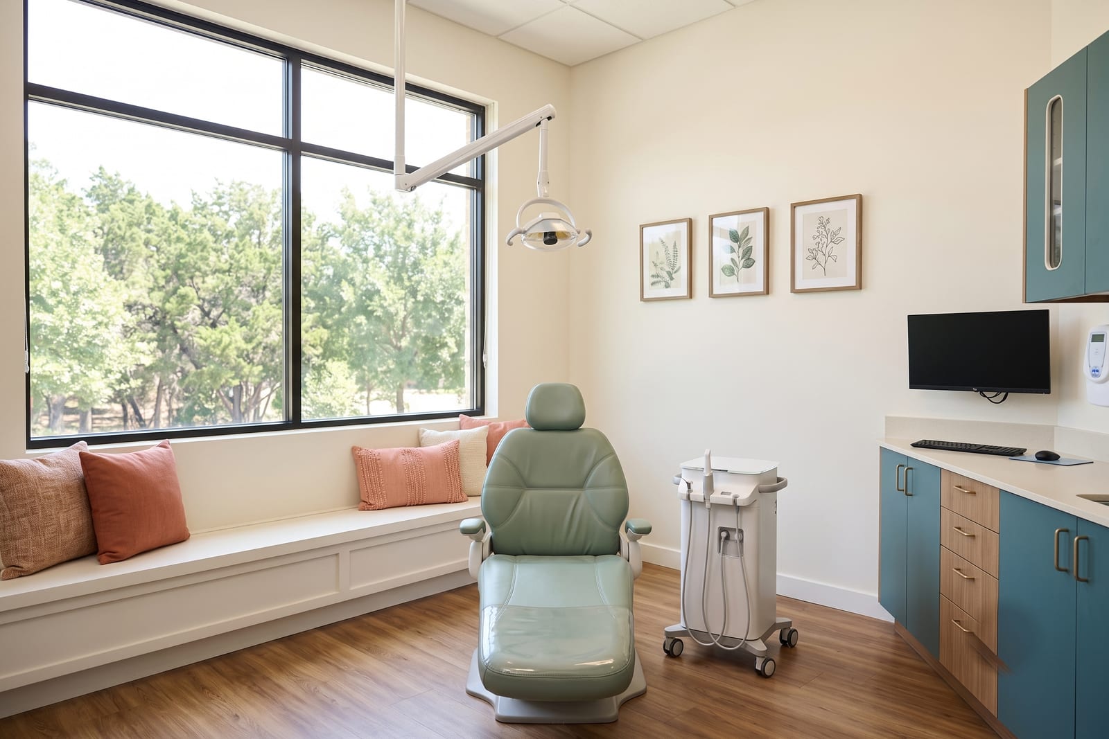 A Ridgeview operatory: sage green chair, chairside monitor, and scanner cart in warm window light